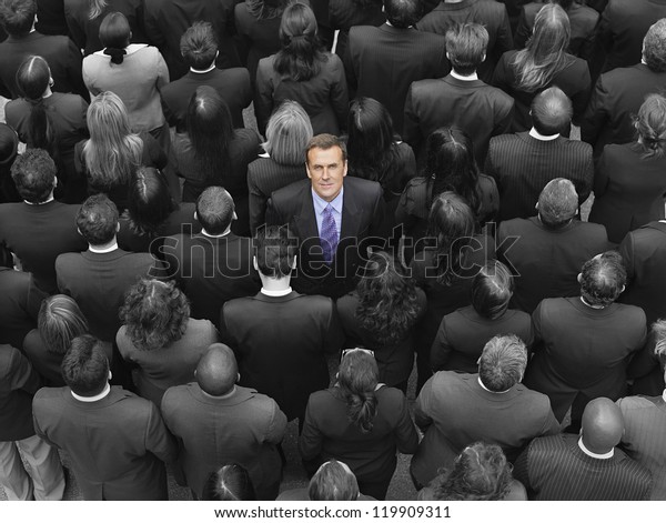 High angle view of a businessman standing\
amidst businesspeople