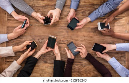 High Angle View Of Businesspeople Hand Using Mobile Phone