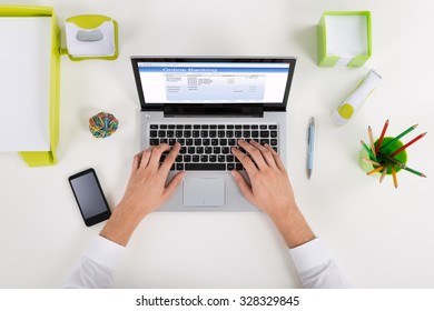 High Angle View Of Businessperson Banking Online On Laptop At Desk