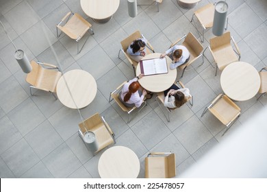 High Angle View Of Businesswomen Doing Paperwork In Office Canteen