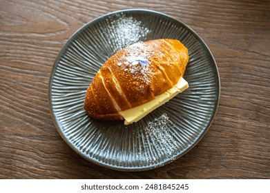 High angle view of a butter pretzel served on wooden table. Pretzels are a type of bread typically made from wheat or rye flour. - Powered by Shutterstock