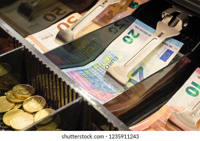 High angle view of cash register drawer full of coins and euro bills
