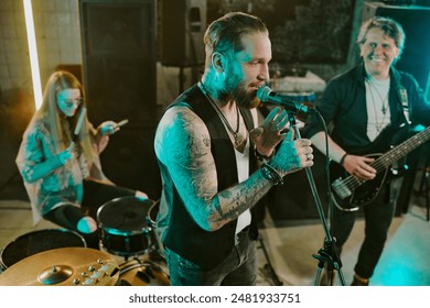 High angle view of Caucasian male vocalist, bassist and female drummer playing punk rock music on stage in bar - Powered by Shutterstock