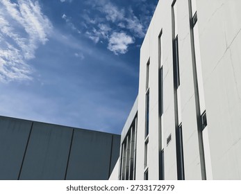 High angle view of city rooftops and modern tall buildings under a clear blue sky during a bright, sunny morning.