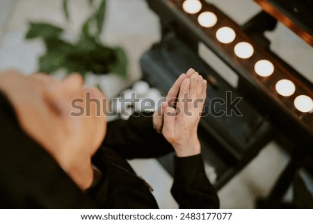 High angle view closeup of unrecognizable mature Caucasian nun praying to God in front of altar