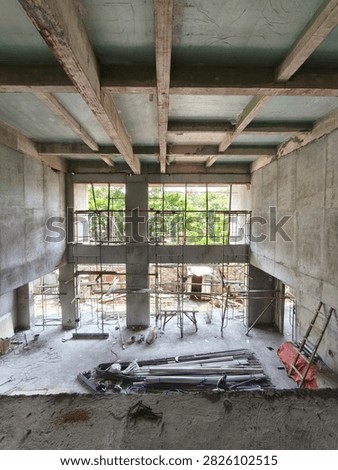 High angle view of concrete grid beam ceiling structure at commercial building construction project with steel scaffolding below.
