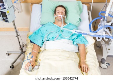 High angle view of critical patient with endotracheal tube resting on bed in hospital