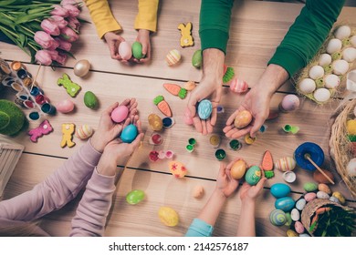High angle view cropped portrait four people arms hold painted eggs festive atmosphere decoration house indoors