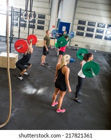 High Angle View Of Crossfit Trainers And Athletes In Weightlifting Class At Gym