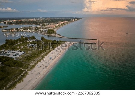 High angle view of crowded Nokomis beach in Sarasota County, USA. Many people enjoing vacations time swimming in ocean water and relaxing on warm Florida sun at sundown