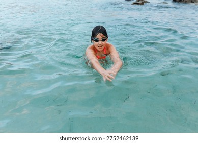 high angle view of a dark haired girl swimming in the sea