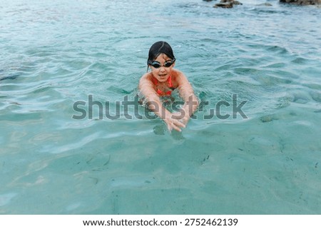 high angle view of a dark haired girl swimming in the sea