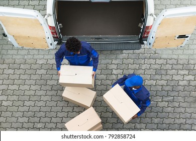 High Angle View Of Delivery Men Unloading The Cardboard Boxes From Truck
