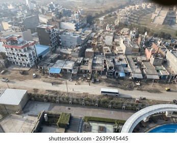High angle view of a densely packed urban area with residential buildings, roads, construction, and visible rooftops showing a mix of activity and infrastructure