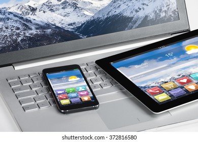 High angle view of digital tablet and smartphones on laptop