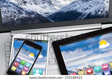 High angle view of digital tablet and smartphones on laptop