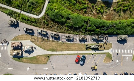 A high angle view directly above vintage tanks and military vehicles. It is a top down shot, taken on a sunny day with a drone on Long Island, New York.