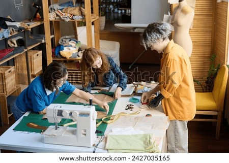 High angle view at diverse group of girls sewing clothes together in inclusive school