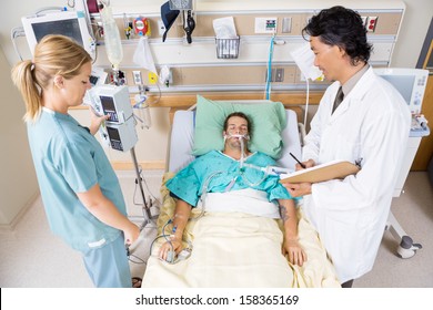 High angle view of doctor and nurse examining critical patient in hospital