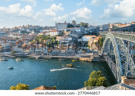 High angle view of the Dom Luis I bridge and the Douro river with several boats and the Ribeira district Porto Portugal.