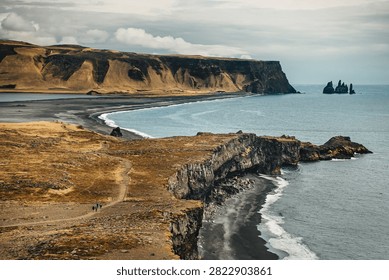 High angle view of dramatic ocean cliffs, endless black sand beach and sea stacks, coastal travel and wilderness concept