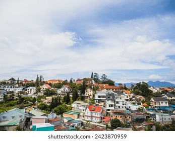High angle view from drone of DALAT city at Vietnam. View over a city with multi coloured houses and shops. Agricultural land outside Dalat in the Central highlands of Vietnam on a sunny day. 