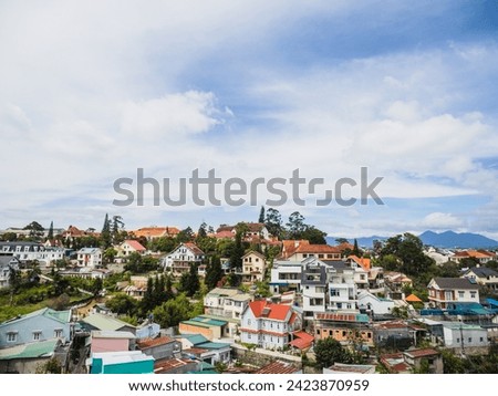 High angle view from drone of DALAT city at Vietnam. View over a city with multi coloured houses and shops. Agricultural land outside Dalat in the Central highlands of Vietnam on a sunny day. 