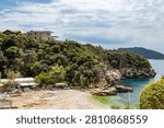 High angle view of empty Buyukcakil pebble beach and quiet bay over deep turquoise sea. Beautiful mediterranean rocky coastal landscape on spring day with modern resort villas, Kas, Turkey.