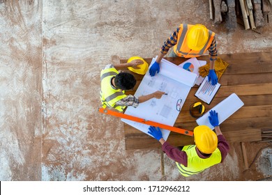 High angle view of engineer and architect discussing building plan at construction site,Group of builders having conversation about building plan. - Powered by Shutterstock