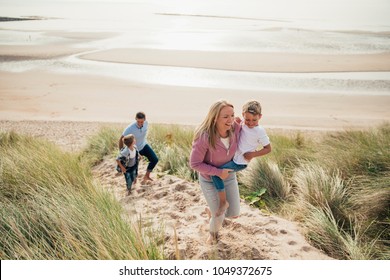 High angle view of a family walking up the sand dune from the beach.