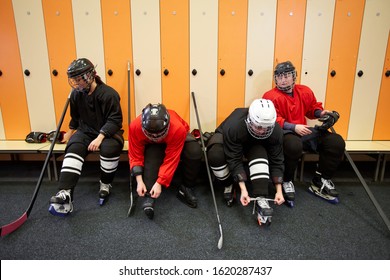 High angle view at female hockey team putting on gear in locker room while preparing for match or practice, copy space - Powered by Shutterstock