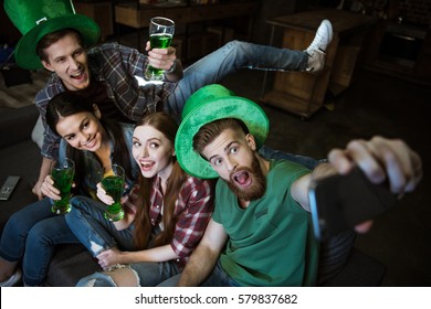 high angle view of friends with beer making selfie on St.Patrick's day - Powered by Shutterstock