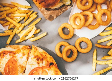 High Angle View Of Friends Eating Burger And French Fries At Table In Cafe.