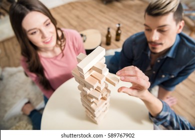 High Angle View Of Friends Playing Jenga Game At Home