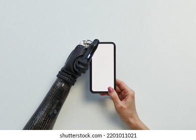 High Angle View Of Girl With Prosthetic Arm Using Mobile Phone On White Background