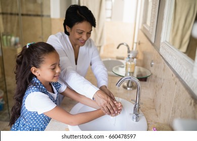 High angle view of grandmother and granddaughter washing hands at bathroom sink, Coronavirus hand washing for clean hands hygiene Covid19 spread prevention