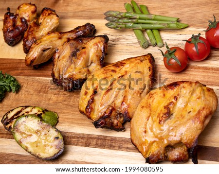 High angle view of grilled chicken kebab on a simple plate. Called Chelo Joojeh in Persian cuisine, as it is served with rice and grilled tomato.Fusion food barbecue concept.
