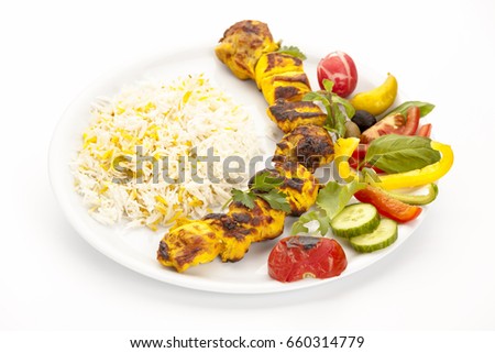 High angle view of grilled chicken kebab on a simple plate. Called chelo joojeh in Persian cuisine, as it is served with rice. Studio shot over a clean white table top. Fusion food barbecue concept.