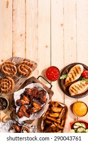 High Angle View of Grilled Meats and Vegetables with Sauces on Wooden Table Surface with Copy Space