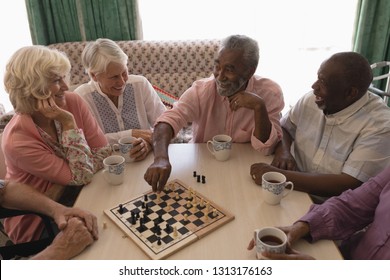 High angle view of group of senior people playing chess on table in living room at nursing home - Powered by Shutterstock