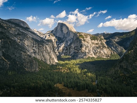 High angle view of Half Dome rock formation and Yosemite valley from mountain on opposite side with blue sky in background 