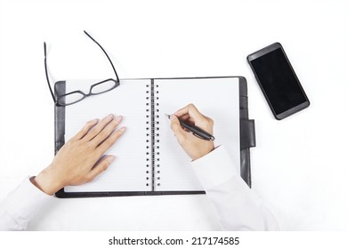 High angle view of hands writing on personal agenda to make a plan