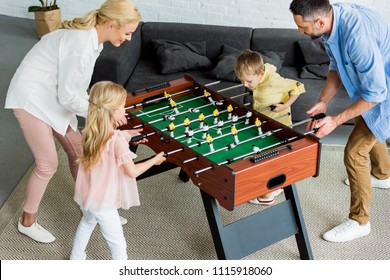 High Angle View Of Happy Family With Two Kids Playing Table Football Together At Home 