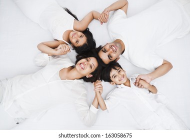 High angle view of a happy family lying on the bed