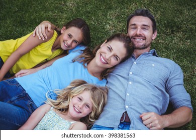 High Angle View Of Happy Family Lying On Field In Back Yard