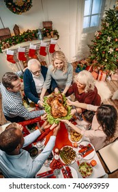 High Angle View Of Happy Large Family Holding Christmas Turkey Together