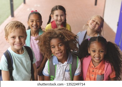 High Angle View Of Happy School Kids Smilling And Looking At The Camera Against Corridor In Background