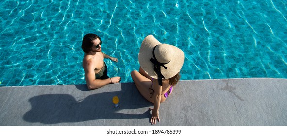High angle view of happy young couple by the pool. couple are relaxing at swimming pool party. Summer vacation concept