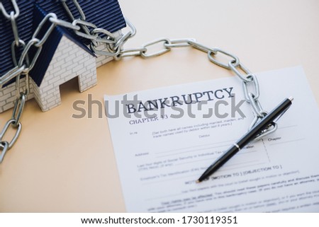 High angle view of house model with chain near pen and document with bankruptcy and chapter 13 lettering on beige