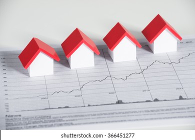 High Angle View Of House Models On Financial Chart At Office Desk